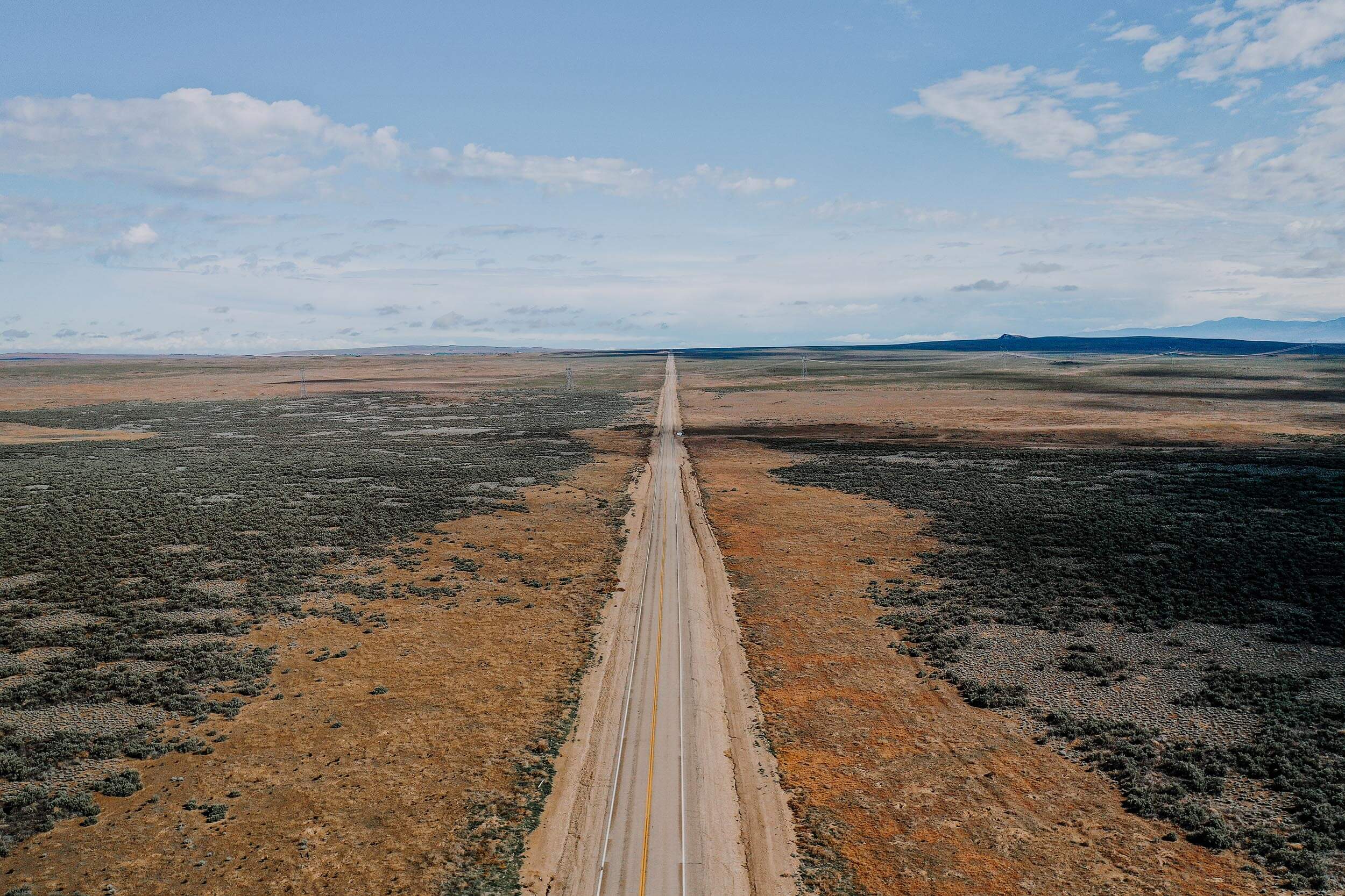 a long stretch of road running through a desert landscape
